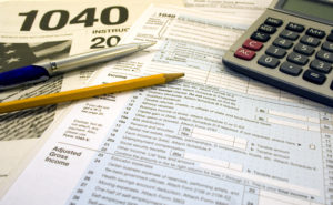 US Tax forms with pen pencil glasses calculator